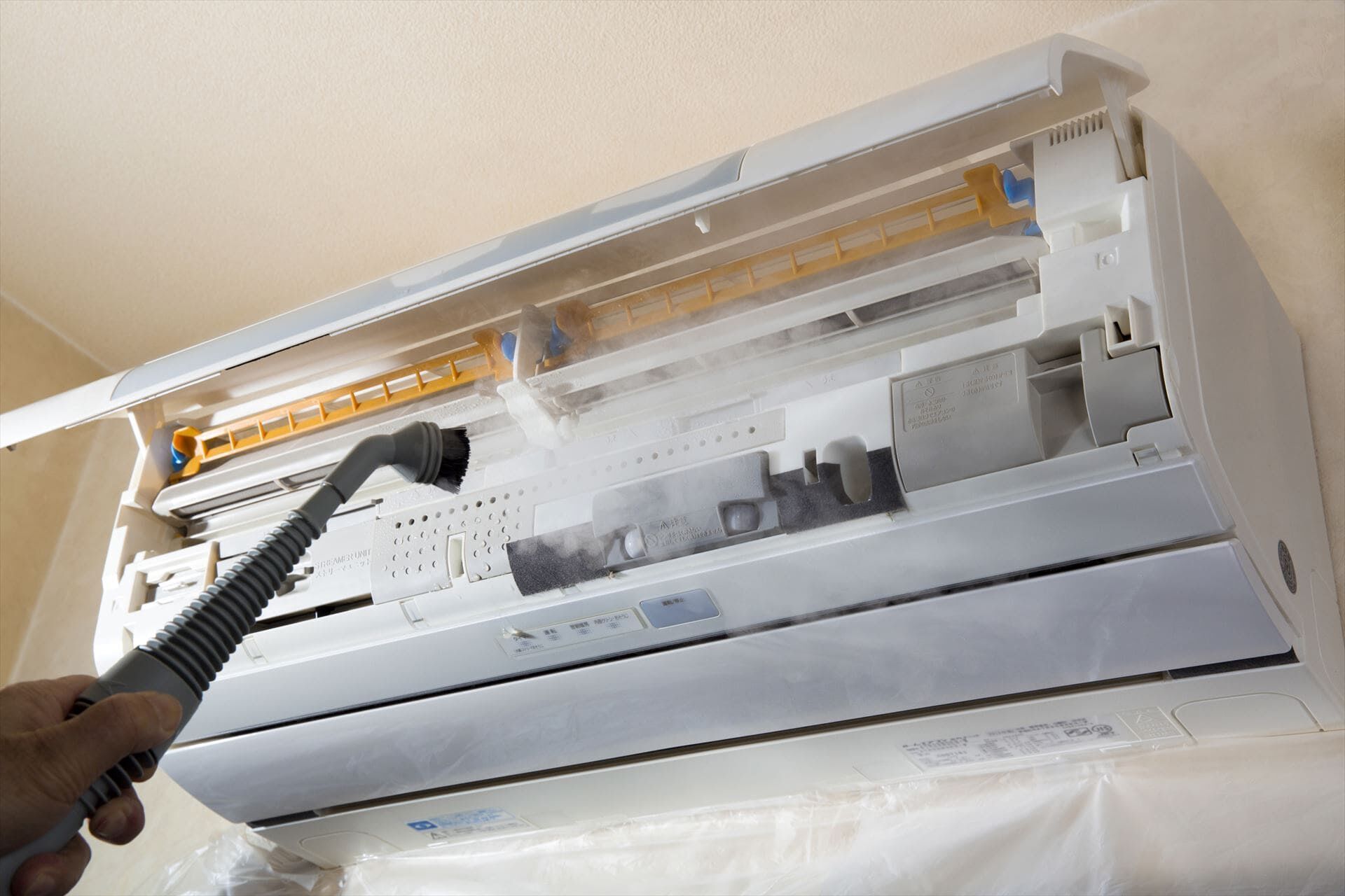 ハウスクリーニングでエアコン清掃するスタッフ